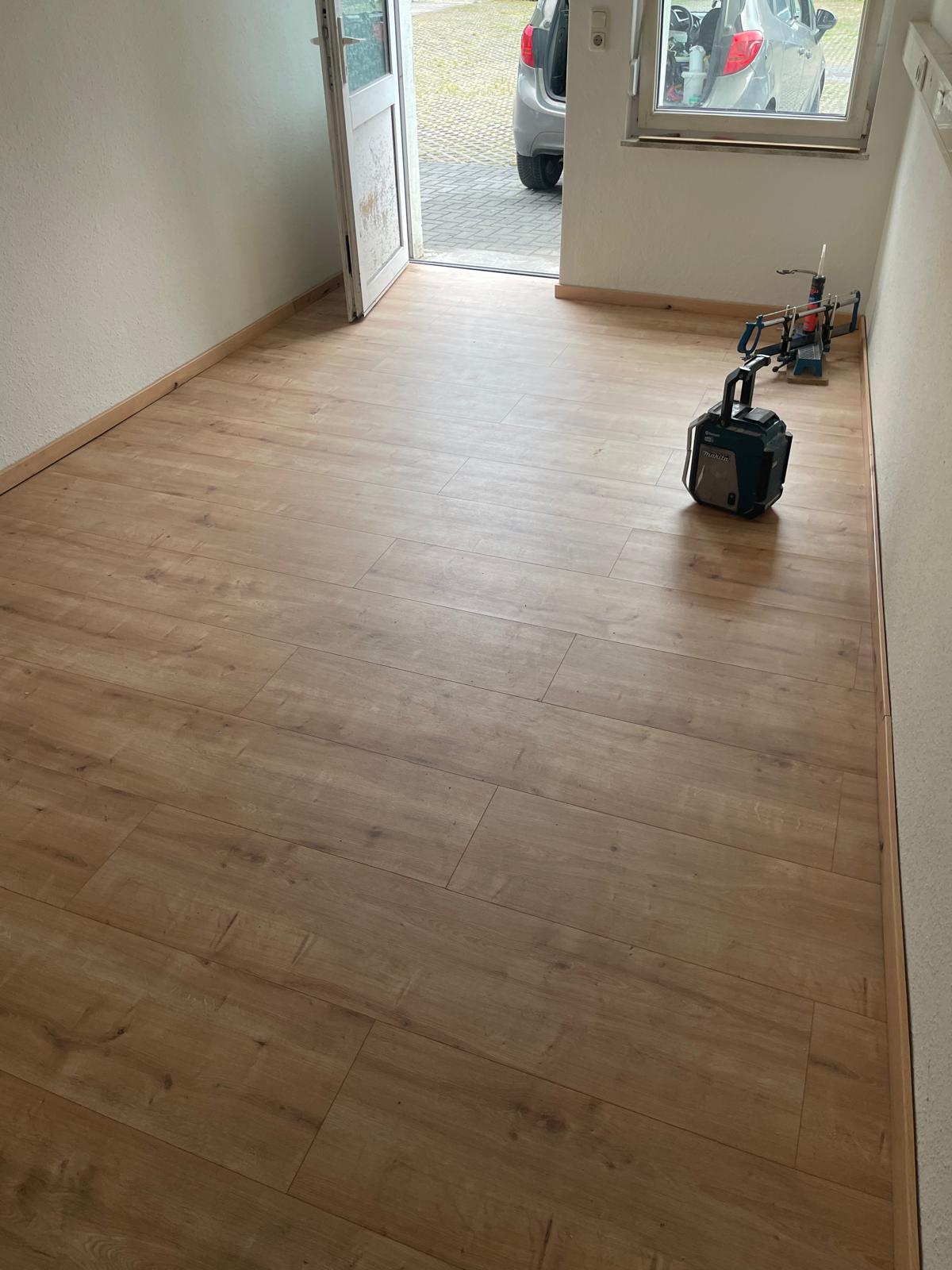 Fertig verlegte Laminatfläche mit montierten Sockelleisten
